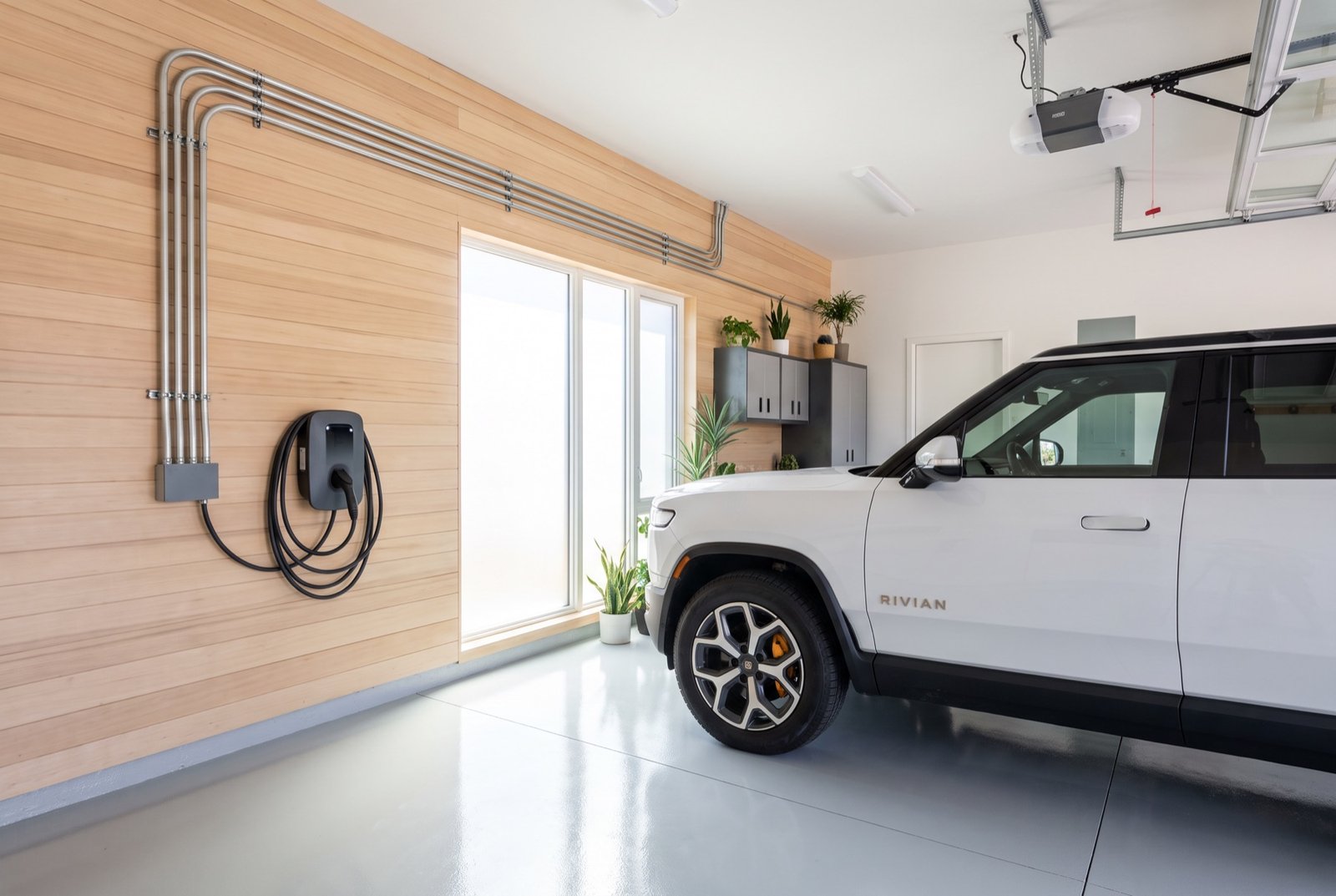 Level 2 EV charger installed in a clean modern garage with an electric SUV plugged in